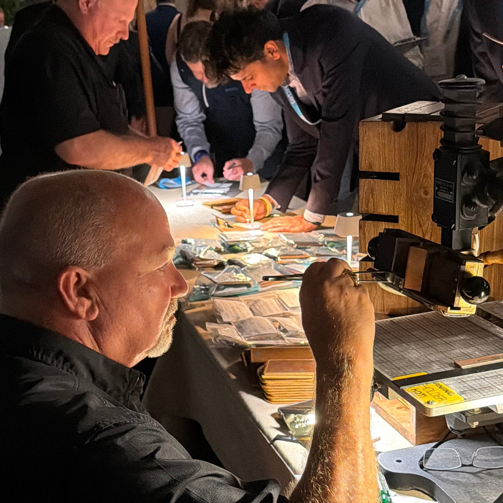 One of our specialists working at a table with hot-stamping tools and materials, surrounded by attendees at an upscale event in Palm Beach, Florida.